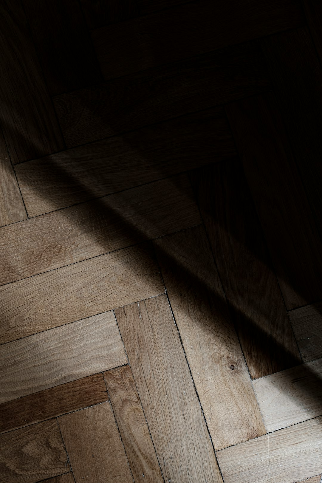 Photo by Lasse Møller a wooden floor with a light shining on it